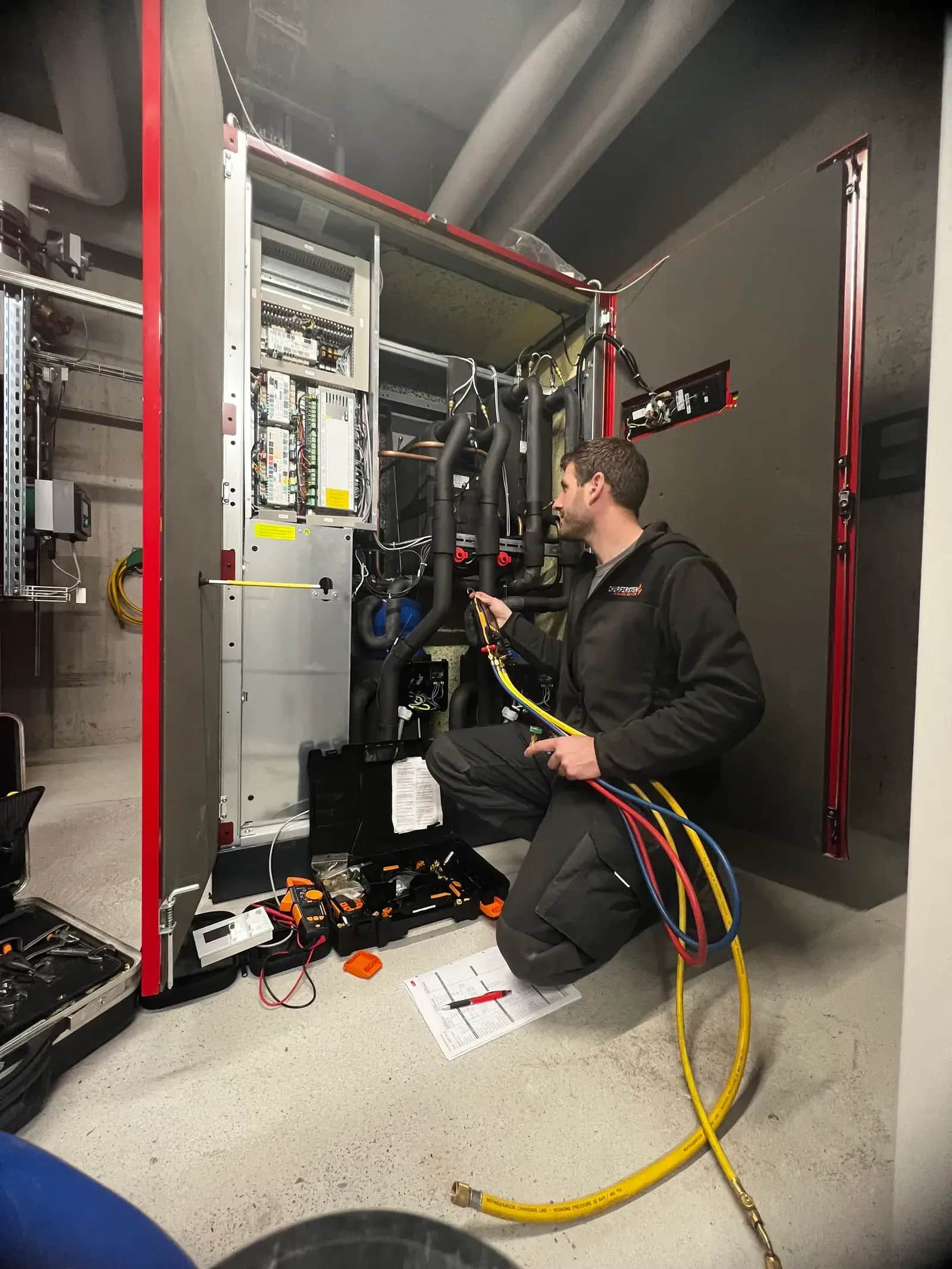 Tobias Klausmann bei der Wärmepumpen-Wartung mit Manometer-Batterie